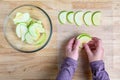 WomanÃ¢â¬â¢s hands taking granny smith apple slices out of a glass bowl and laying them out on a mesh tray for dehydrating Royalty Free Stock Photo